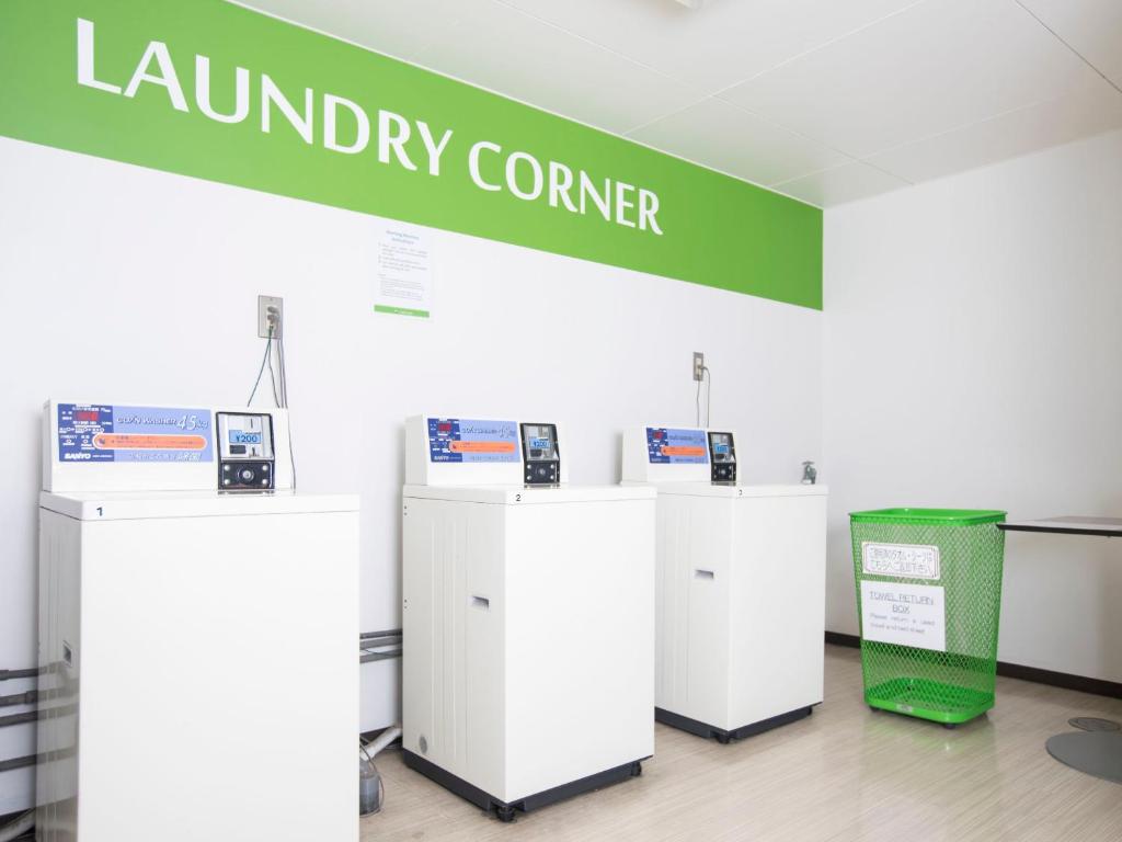 a group of refrigerators in a room with a green sign at FLEXSTAY INN Shinagawa in Tokyo