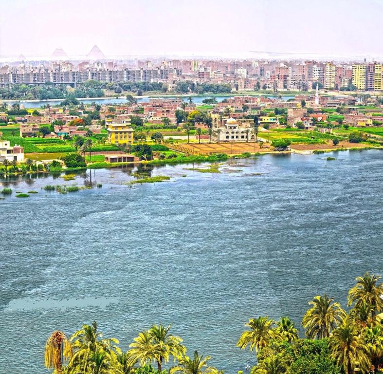 a view of a river with a city in the background at Sultan Cairo Nile Maadi in Cairo