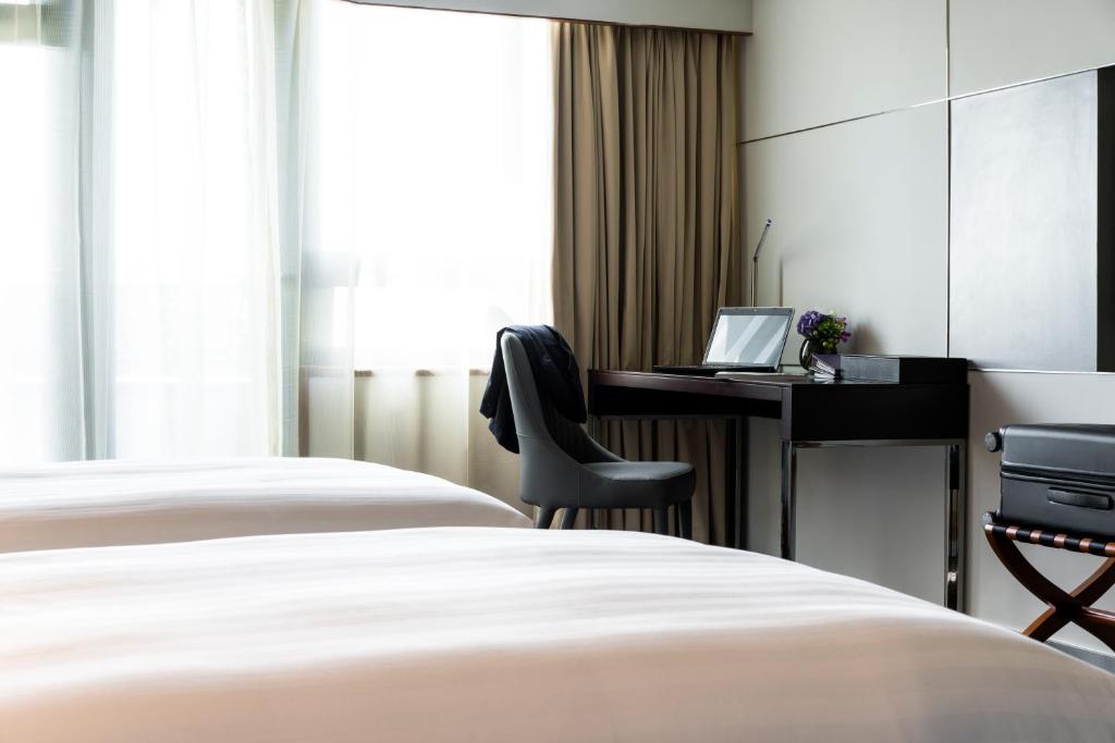 Postel nebo postele na pokoji v ubytování Grand Mercure Shanghai Hongqiao