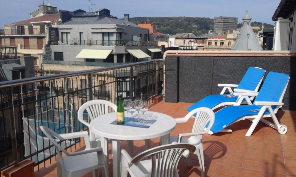 balkon ze stołem i krzesłami na dachu w obiekcie Larramendi Terrace Apartment w mieście San Sebastián