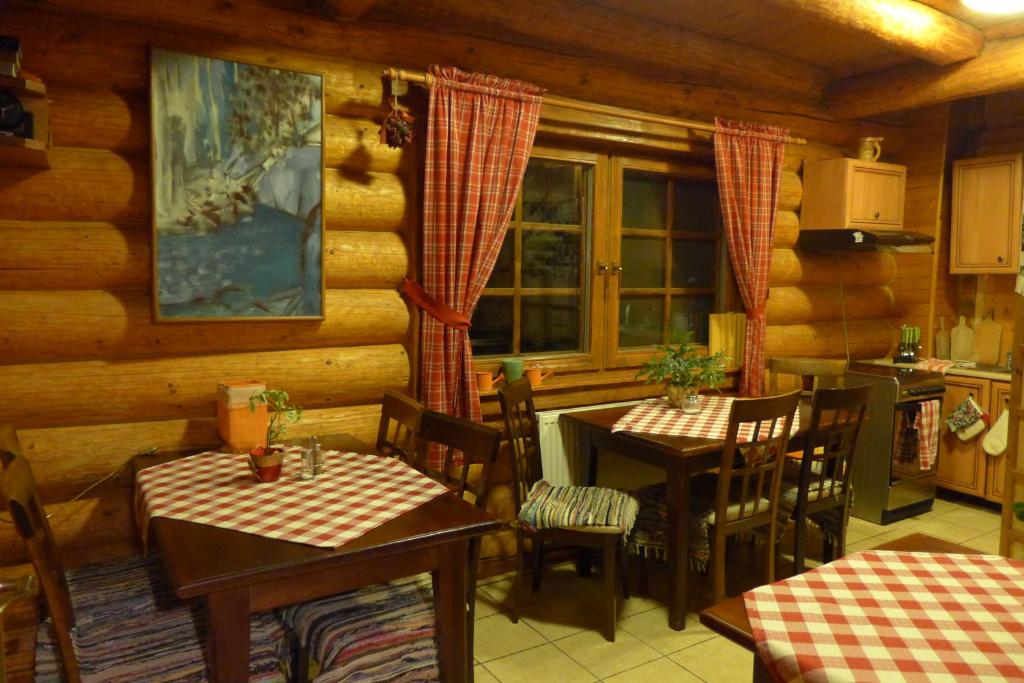 a dining room with two tables and a kitchen at Penzion-Ranc u Trapera in Hrabušice