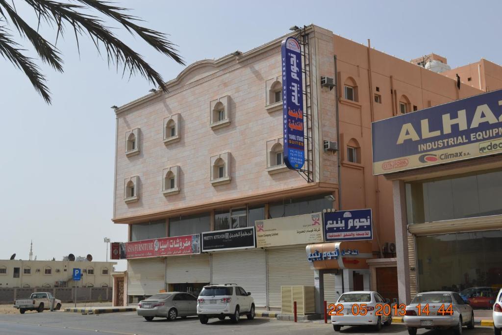 a building with cars parked in front of it at Nojoom Yanbu in Yanbu