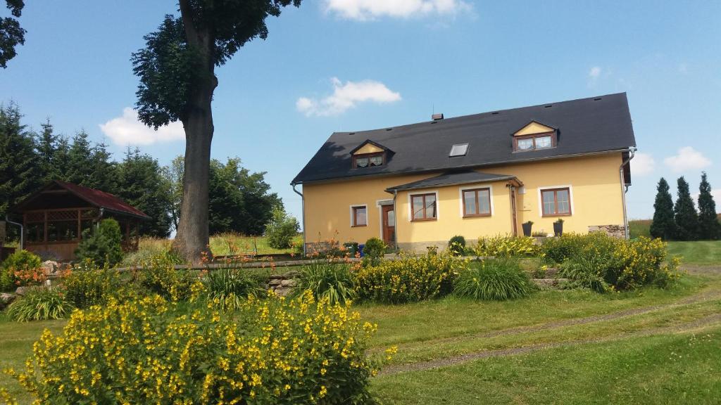 a yellow house with a black roof at Chalupa Háj in Jindřichovice