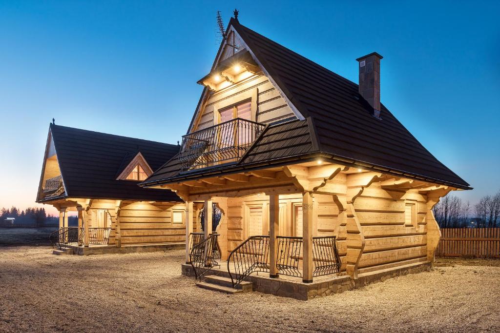 a large wooden cabin with a black roof at Chochołowskie Domki in Chochołów