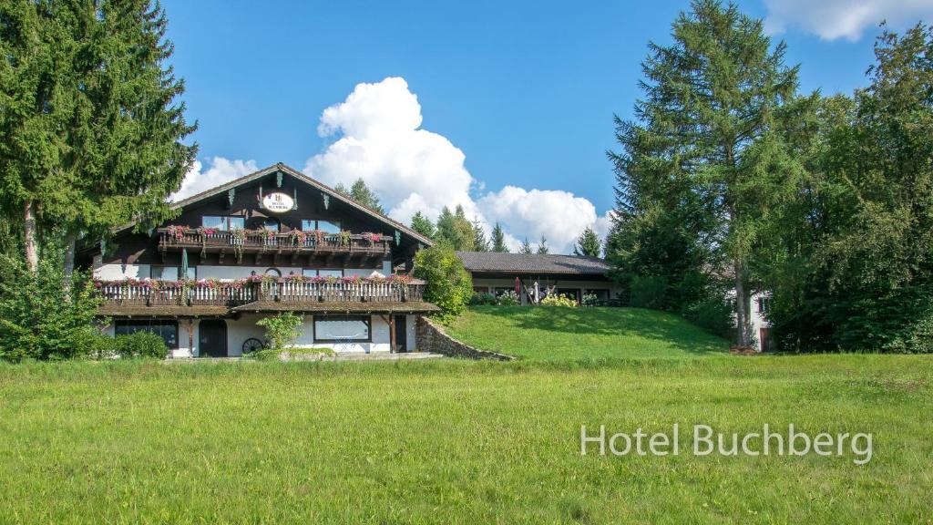 ein großes Haus auf einem Hügel mit grünem Feld in der Unterkunft Hotel Buchberg in Schönsee