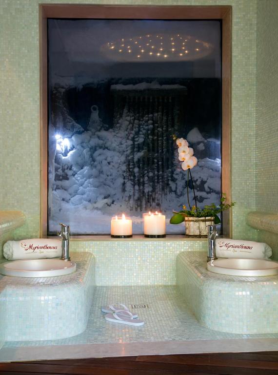 a bathroom with two sinks with candles and a picture at Casale Panayiotis in Kalopanayiotis