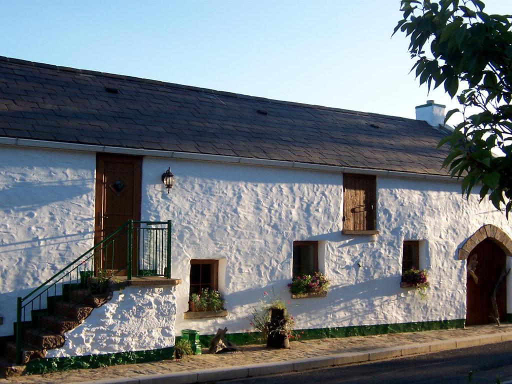 un edificio blanco con una escalera delante en The Bothy Self Catering Accommodation, en Rousky