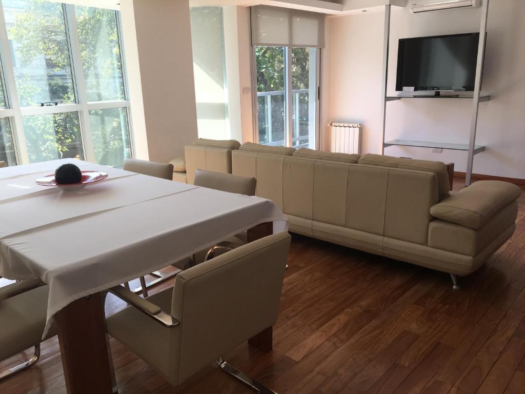 sala de estar con mesa y sofá en Apart Edificio Clever en La Plata
