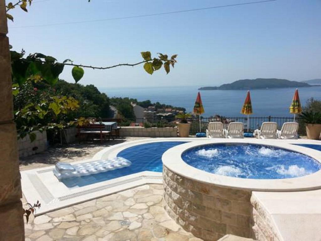 a swimming pool with chairs and a view of the ocean at Villa Royal Dream in Sveti Stefan