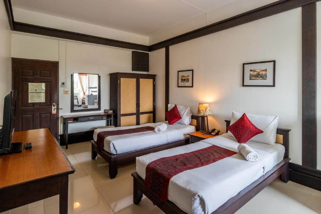 A twin room with two separate beds, a desk and a wardrobe.