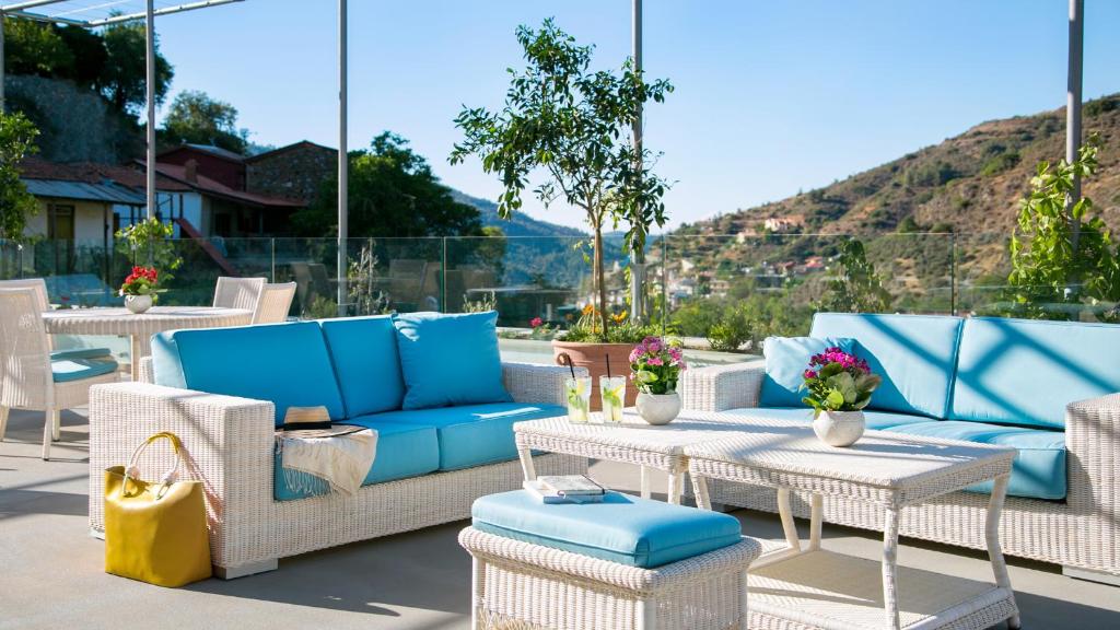 a patio with blue and white chairs and tables at Casale Panayiotis in Kalopanayiotis