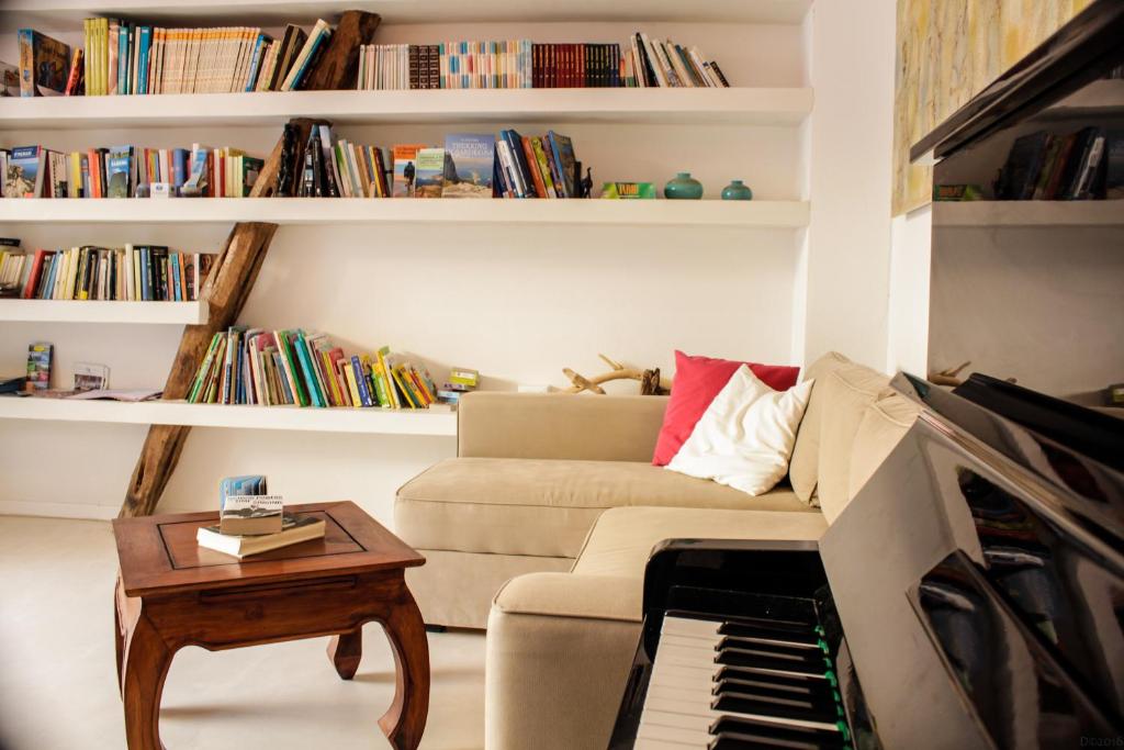 a living room with a couch and a piano at Casa Saba in Orosei