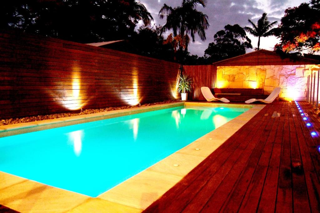 a swimming pool in a backyard at night at Reiki Spectacular House in Gold Coast