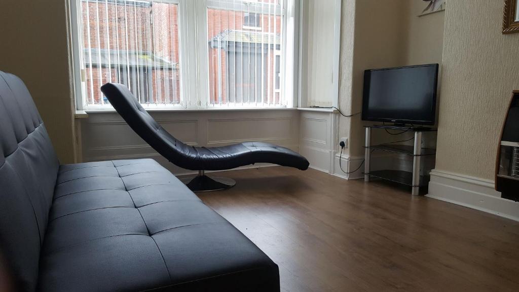 a living room with a leather chair and a television at Blackpoolholidaylets Charles Street in Blackpool