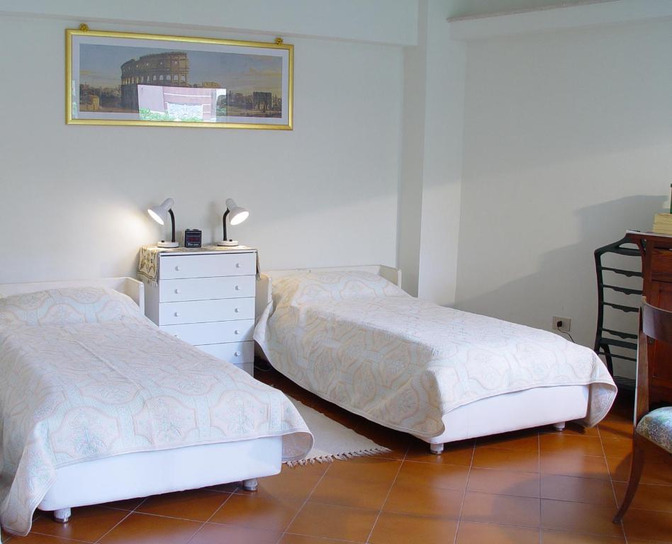 ローマにあるBUONE VACANZE A ROMA!のベッドルーム1室(ベッド2台、ドレッサー、鏡付)