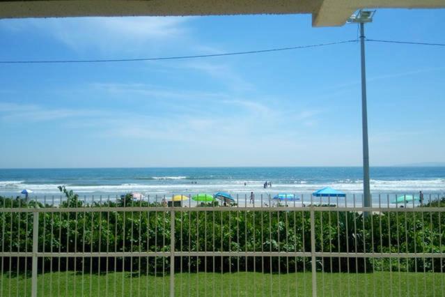 a view of a beach with a fence and the ocean at Apartamento - Pé na Areia in Itapema