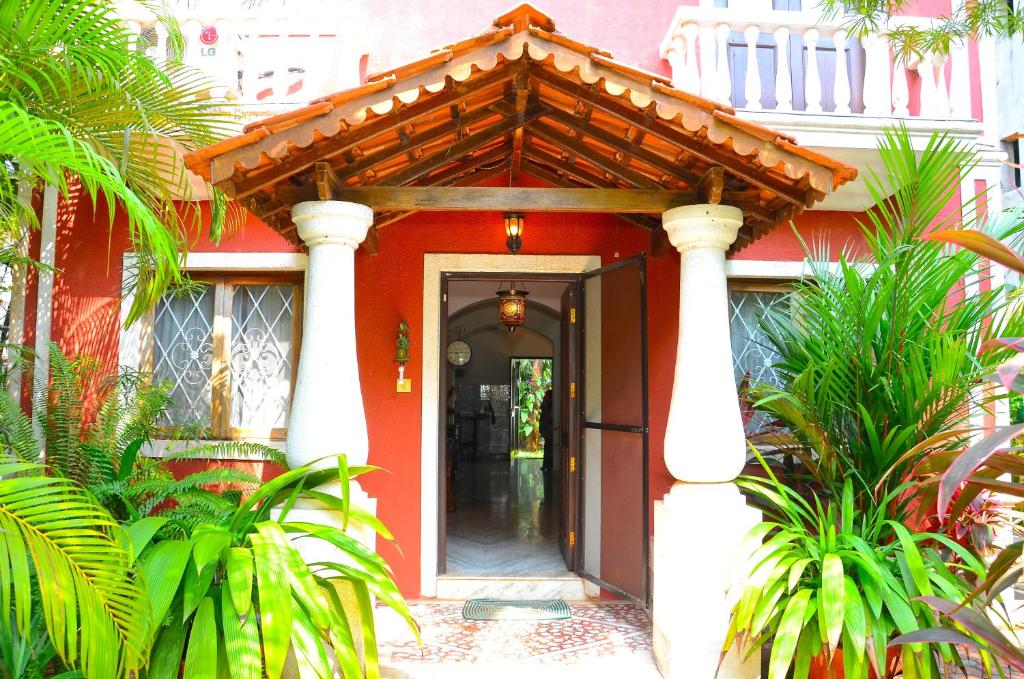 an entrance to a red building with a wooden roof at Villa Samaara9 Candolim Beach in Candolim