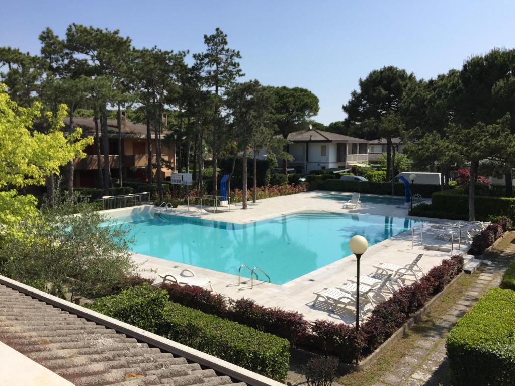 a swimming pool in a yard with trees at Fenice in Bibione