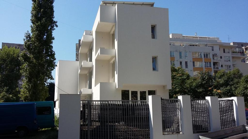 a white building with a fence in front of it at La Caramidari Bucuresti in Bucharest