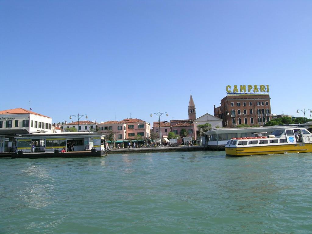two boats are docked on a river in a city at Hotel Belvedere in Venice-Lido