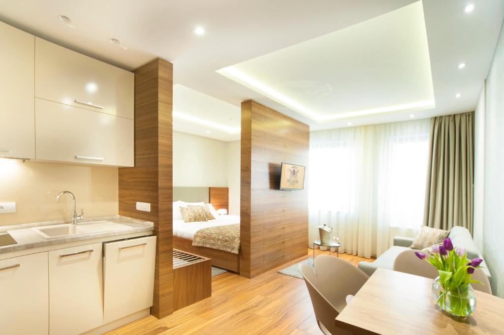 una cucina e un soggiorno con un letto sullo sfondo di NV Luxury Suites & Spa a Belgrado