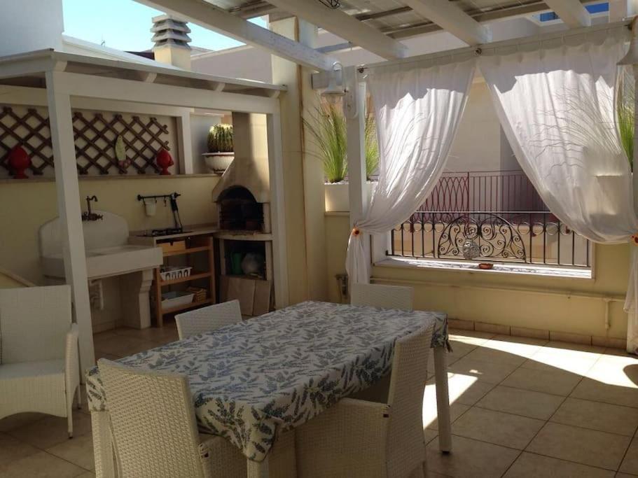 a table and chairs in a room with a balcony at Casa Sirena, Locazione Turistica in Polignano a Mare