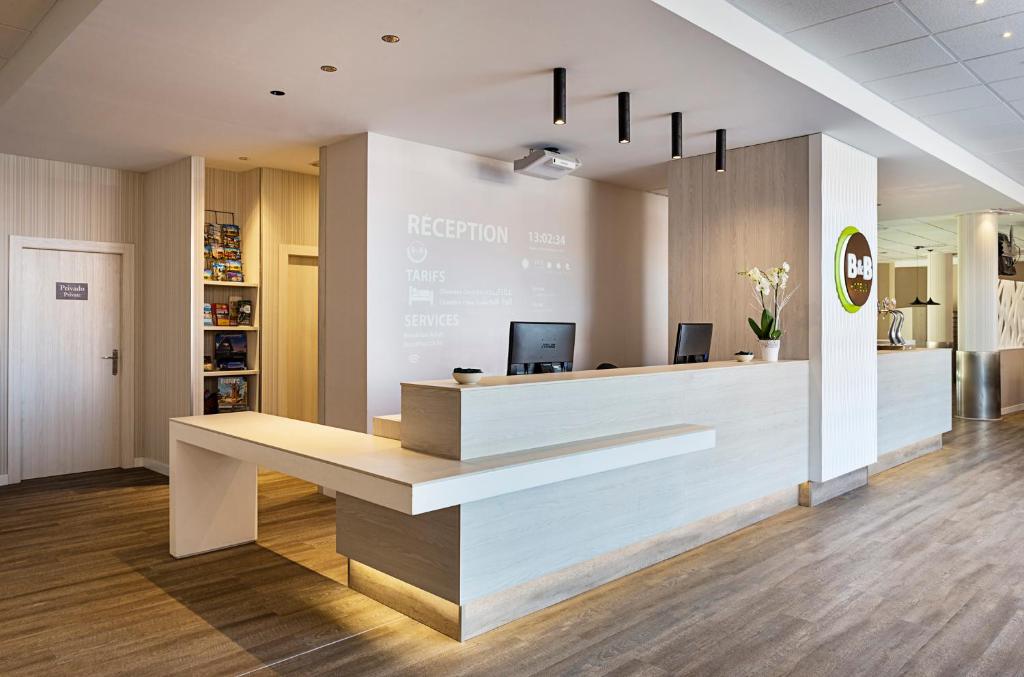 an office lobby with a reception desk and a sign at B&B HOTEL Valencia Ciudad de las Ciencias in Valencia