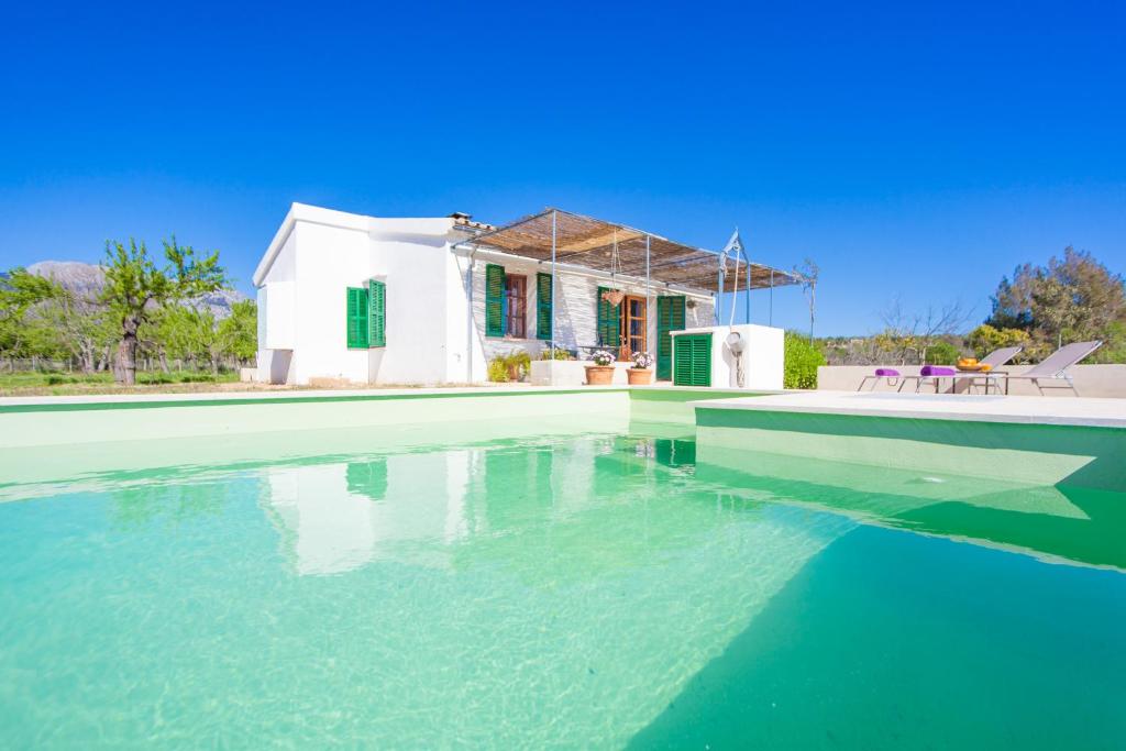 une villa avec une piscine en face d'une maison dans l'établissement Ses Planes - Adults Only ( Ca Na Faustina), à Selva