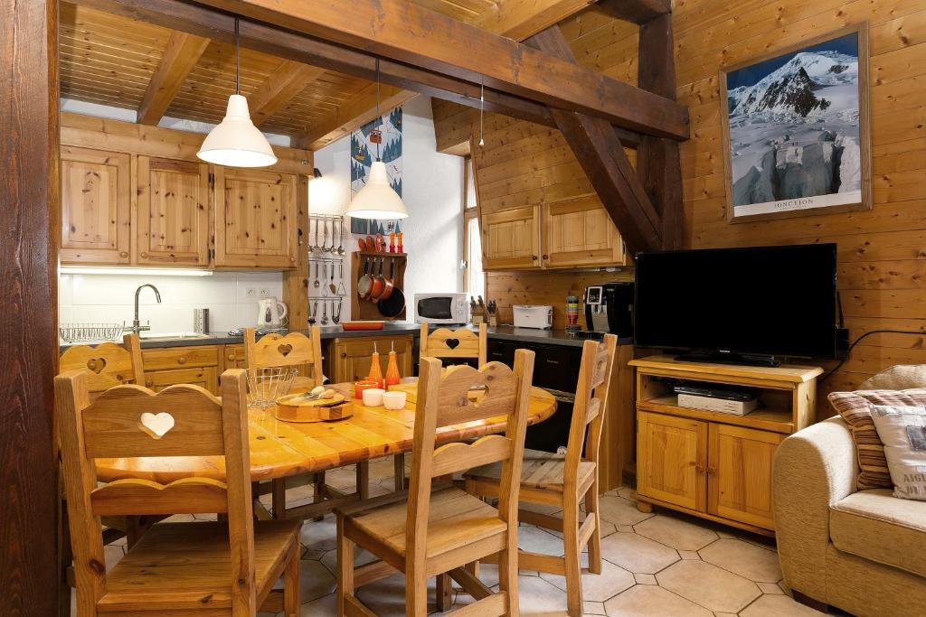 eine Küche und ein Esszimmer mit einem Holztisch und Stühlen in der Unterkunft Apartment Vila 1 in Chamonix-Mont-Blanc