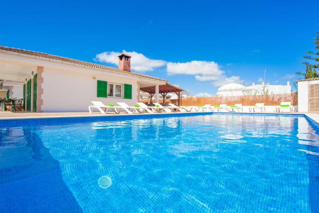 - une piscine avec des chaises et une maison dans l'établissement Rodriguez De La Fuente 19 (Sin Nombre), à Playa de Muro