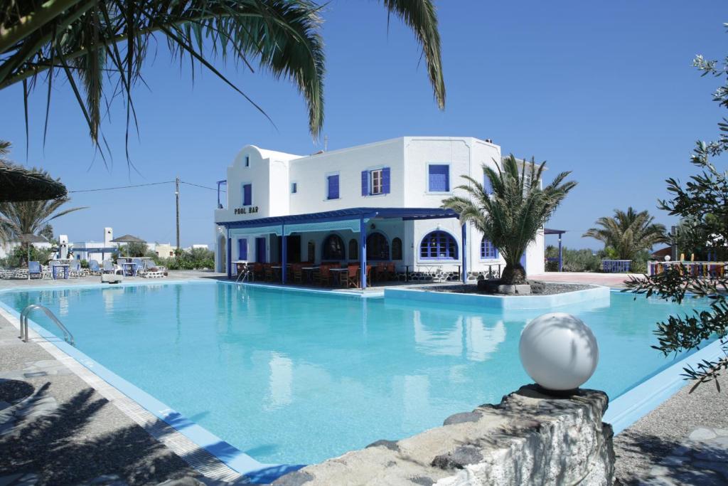 a large swimming pool in front of a white building at Hotel Perissa in Perissa
