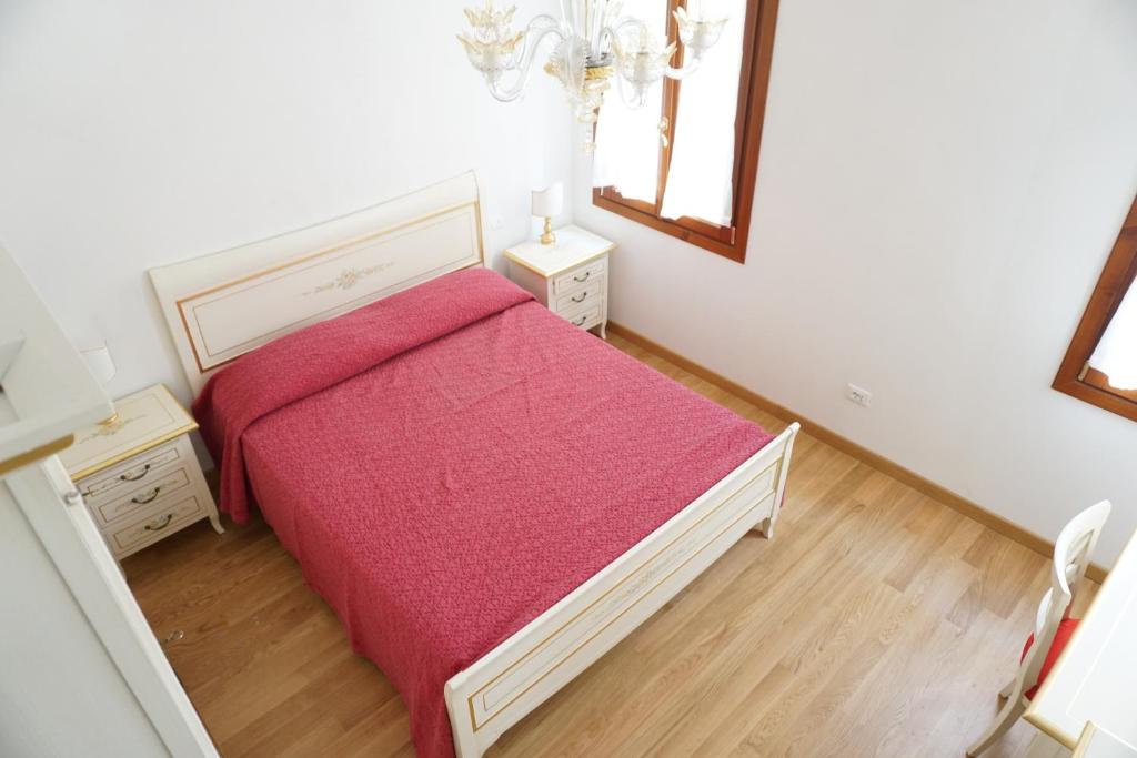 a bedroom with a bed with a red blanket at B & B Nina in Venice
