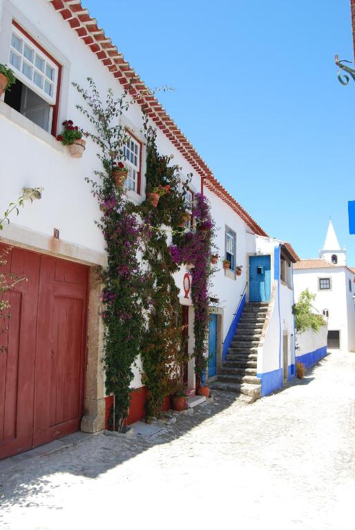 a house with flowers on the side of it at Casa Maria Obidos in Óbidos