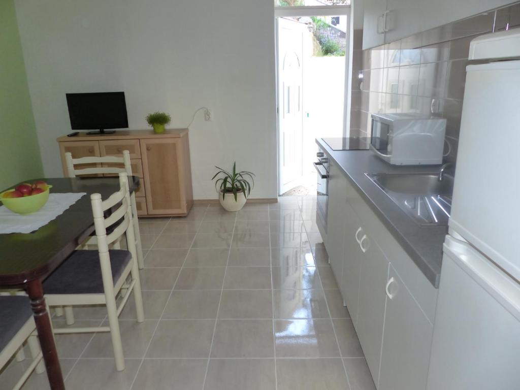 a kitchen with a table and a sink and a counter at Apartments Smiljana in Omiš