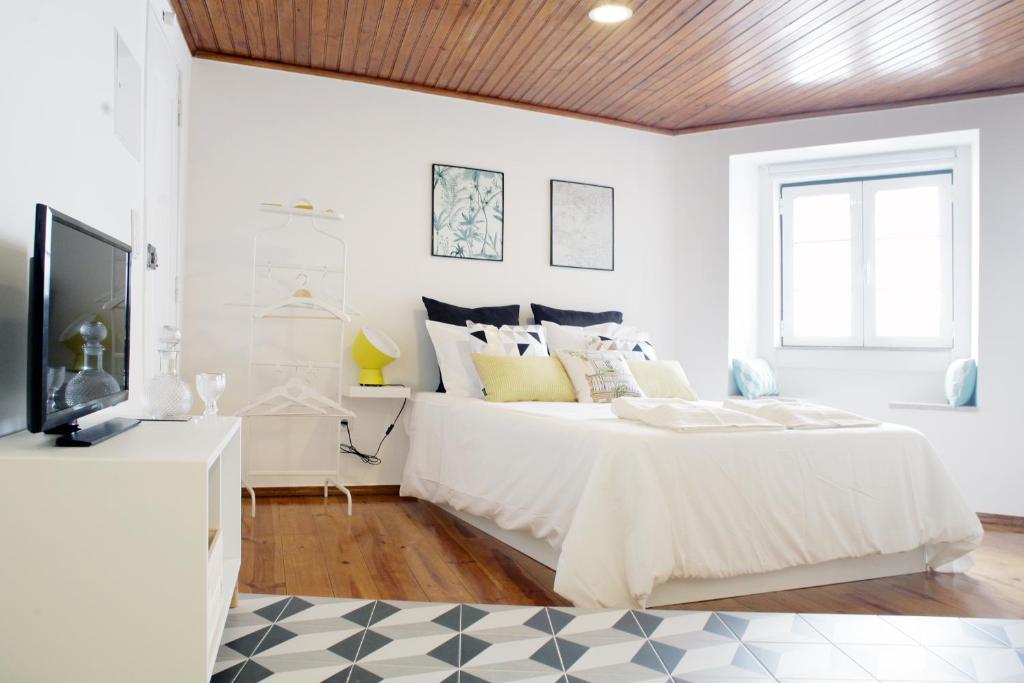um quarto branco com uma cama e uma televisão em Alfama Apartment Rose - Guitarra em Lisboa