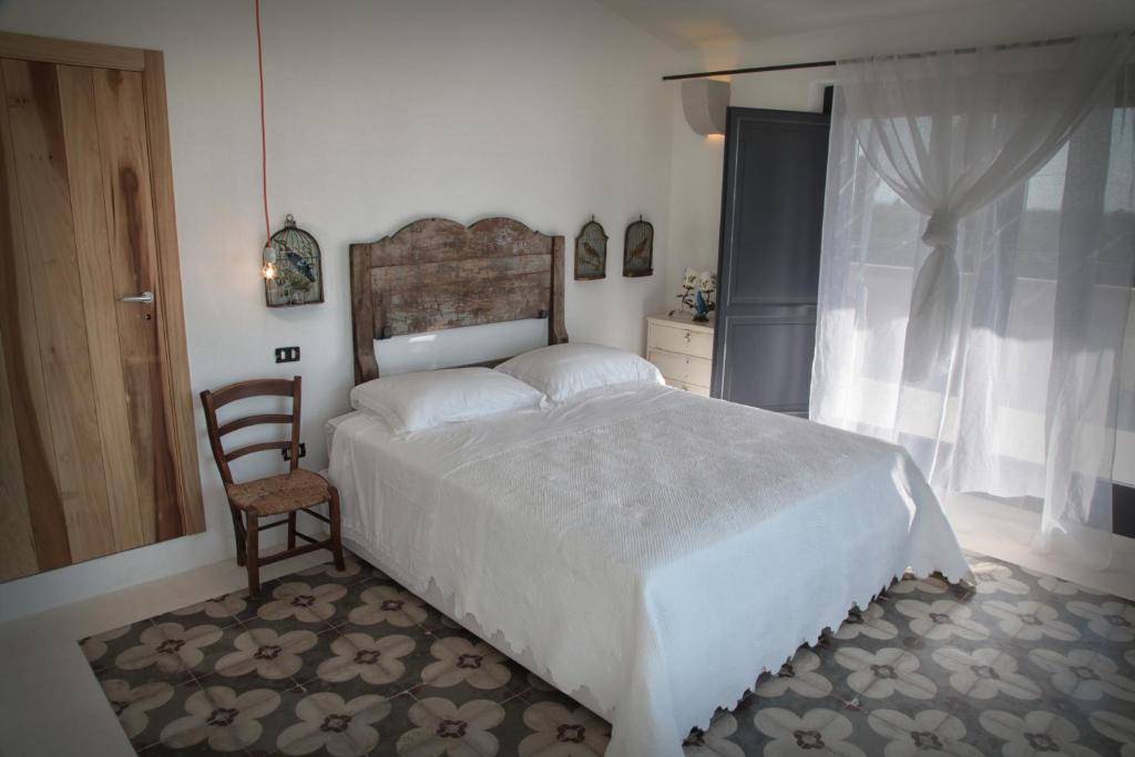 ein Schlafzimmer mit einem Bett, einem Stuhl und einem Fenster in der Unterkunft Masseria Prosperi in Alimini