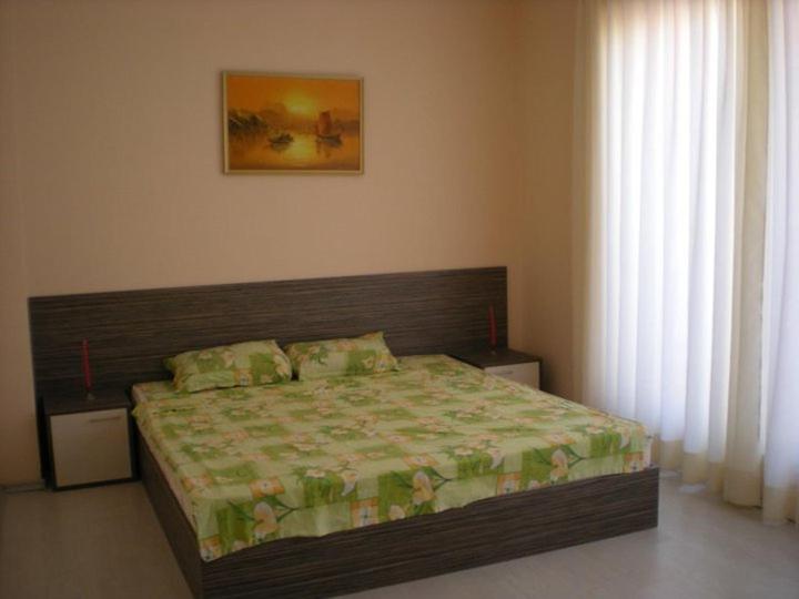 サニービーチにあるAngel Apartment - Kalina Angelovaのベッドルーム1室(木製ヘッドボード付きのベッド1台付)