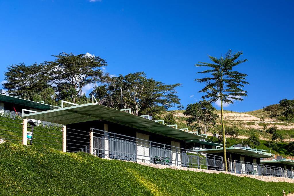 uma casa numa colina com uma palmeira em Hotel Fazenda Terra dos Sonhos em Bueno Brandão