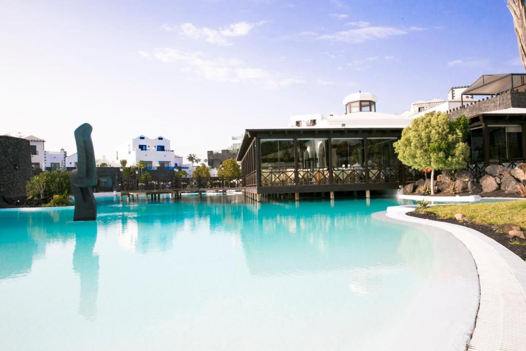 a large swimming pool with a building in the background at Hotel LIVVO Volcán Lanzarote in Playa Blanca