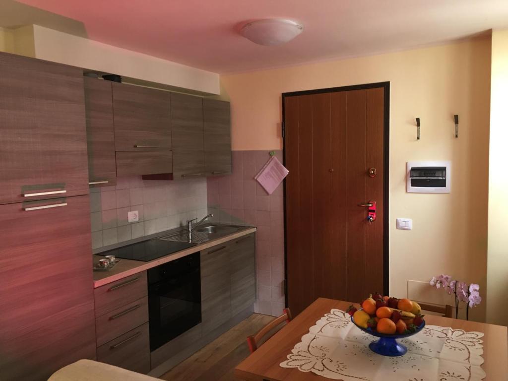 a kitchen with a table with a bowl of fruit on it at La Maison di La Thuile in La Thuile