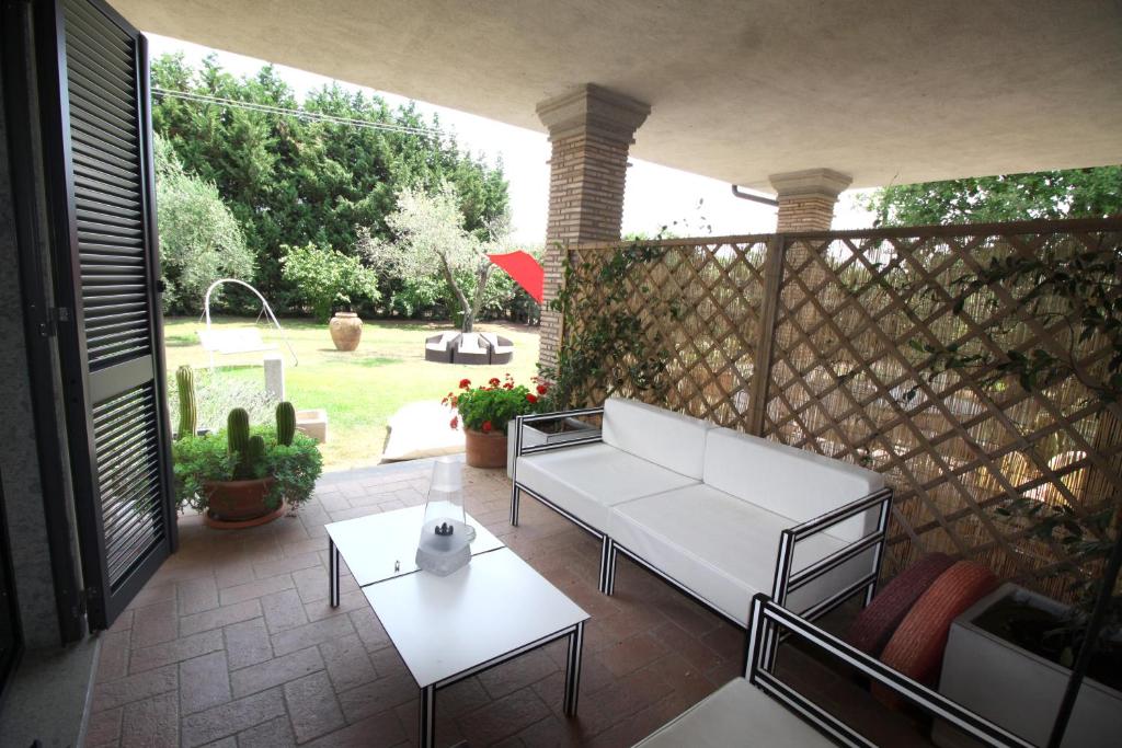 un patio con un sofá blanco y una mesa en Bed and breakfast Ellera Viterbo, en Viterbo