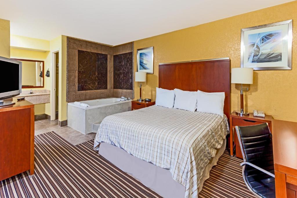 una camera d'albergo con un letto e una vasca da bagno di Lodge at Mill Creek Pigeon Forge a Pigeon Forge