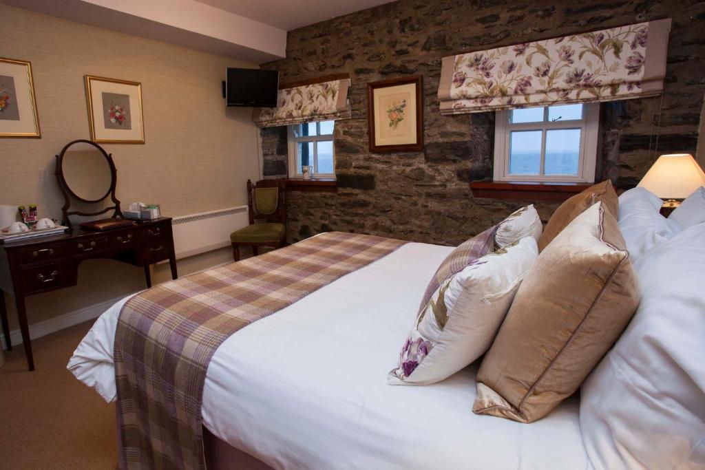 a bedroom with a large bed with pillows at Port Charlotte Hotel in Port Charlotte