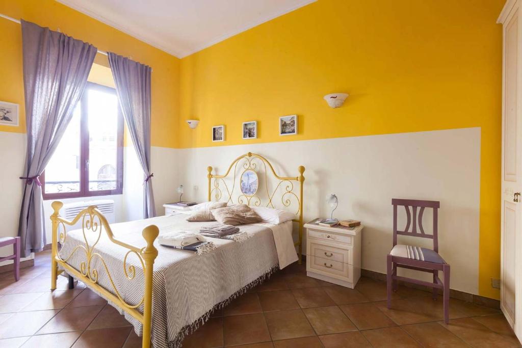 Trastevere Dream House في روما: غرفة نوم بسرير وجدار اصفر