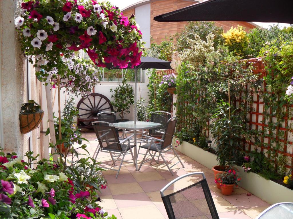 een patio met een tafel, stoelen en bloemen bij The Florida Guest House in Paignton