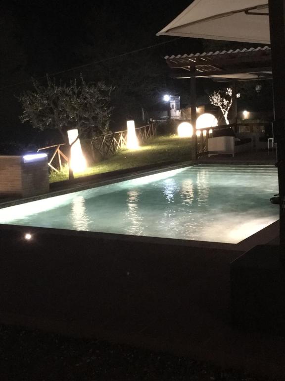 a swimming pool at night with lights at Villa valtopina in Valtopina