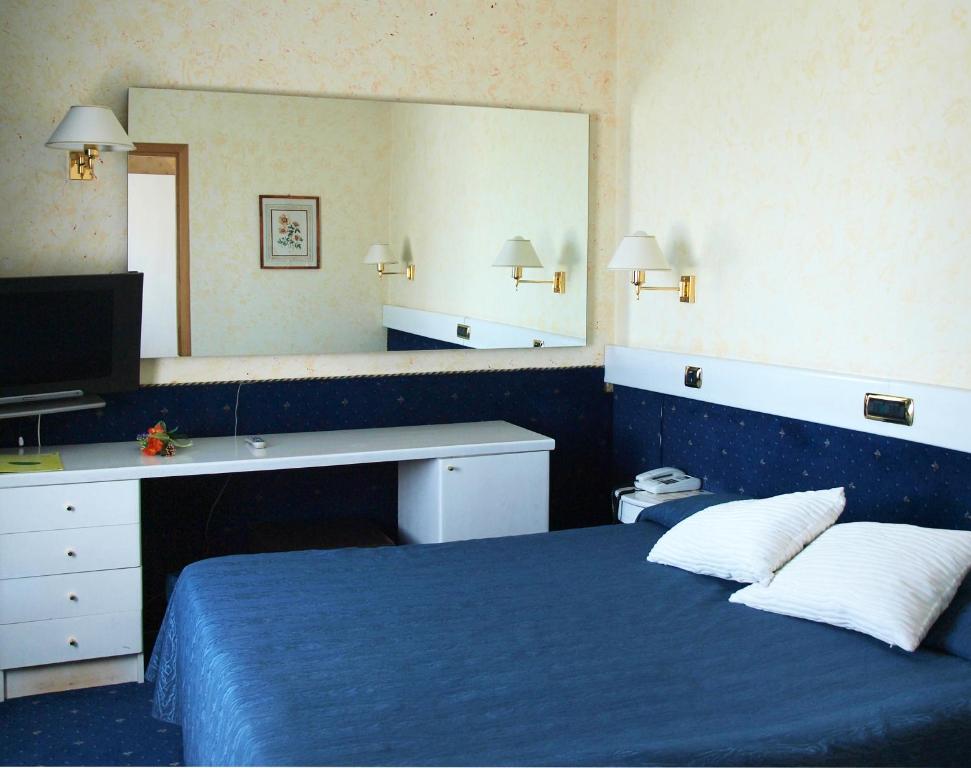 een slaapkamer met een blauw bed en een grote spiegel bij Eurohotel in Piacenza
