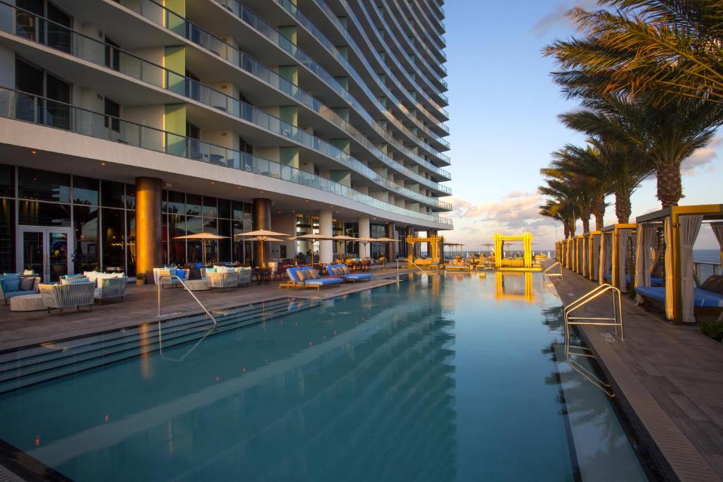 un hotel con una piscina con palmeras y un edificio en Lyfe Resort & Residences, en Hollywood