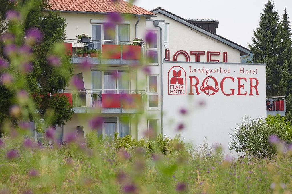 a hotel with a sign on the side of a building at Flair Hotel Landgasthof Roger in Löwenstein
