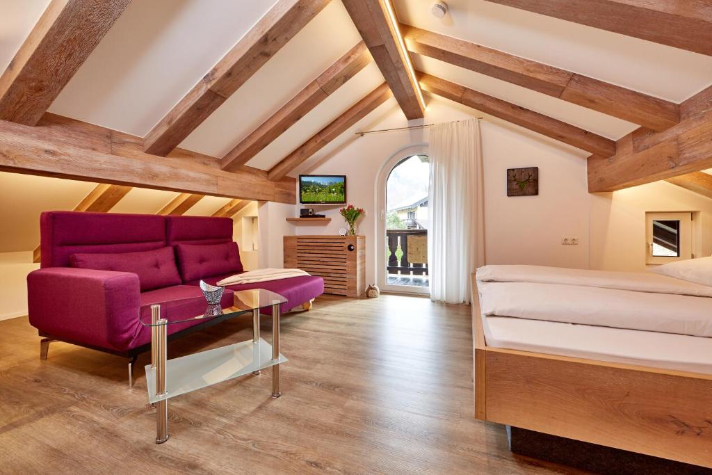 a bedroom with a purple bed and a couch at Ferienwohnung Wittmann in Garmisch-Partenkirchen